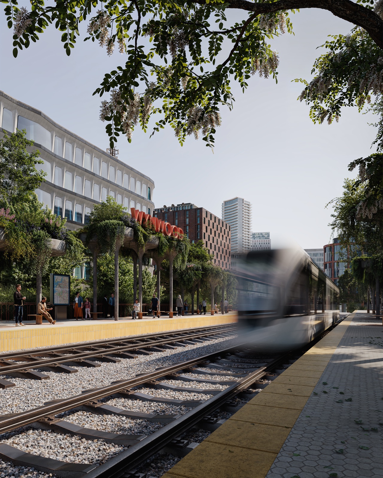 The Wynwood train platform near The Rider Residences — a station beneath the iconic red 'WYNWOOD' sign with a commuter train arriving, just 85 yards from the building at 94 NE 29th Street.
